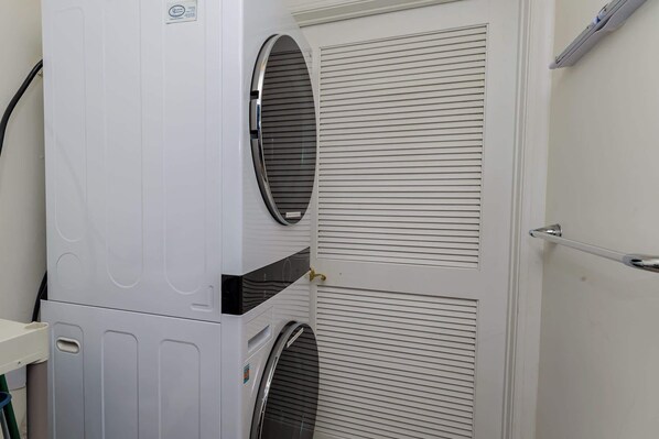 A white wall with two windows and a door.