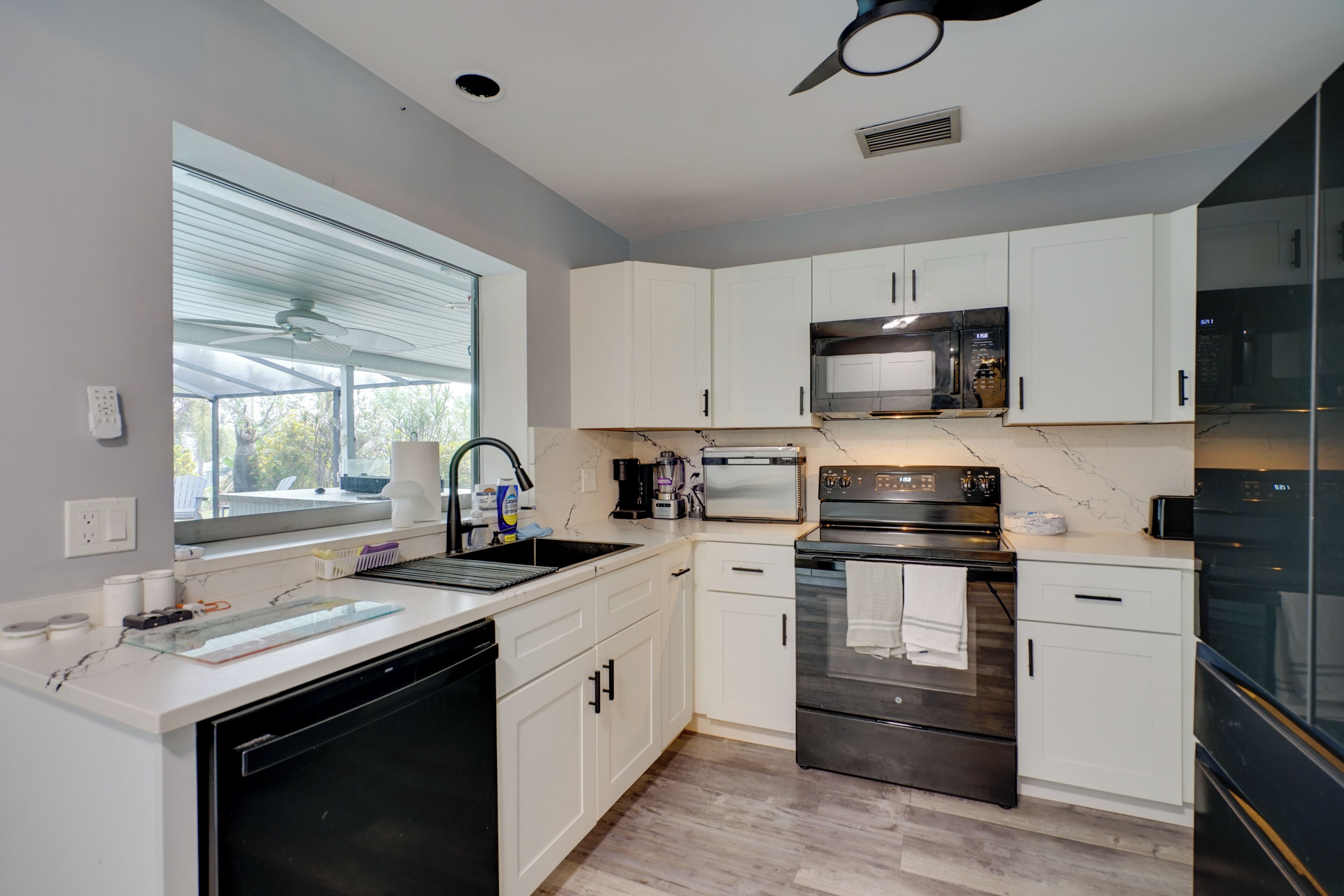 A modern kitchen with white cabinets, stainless steel appliances, and a dishwasher.