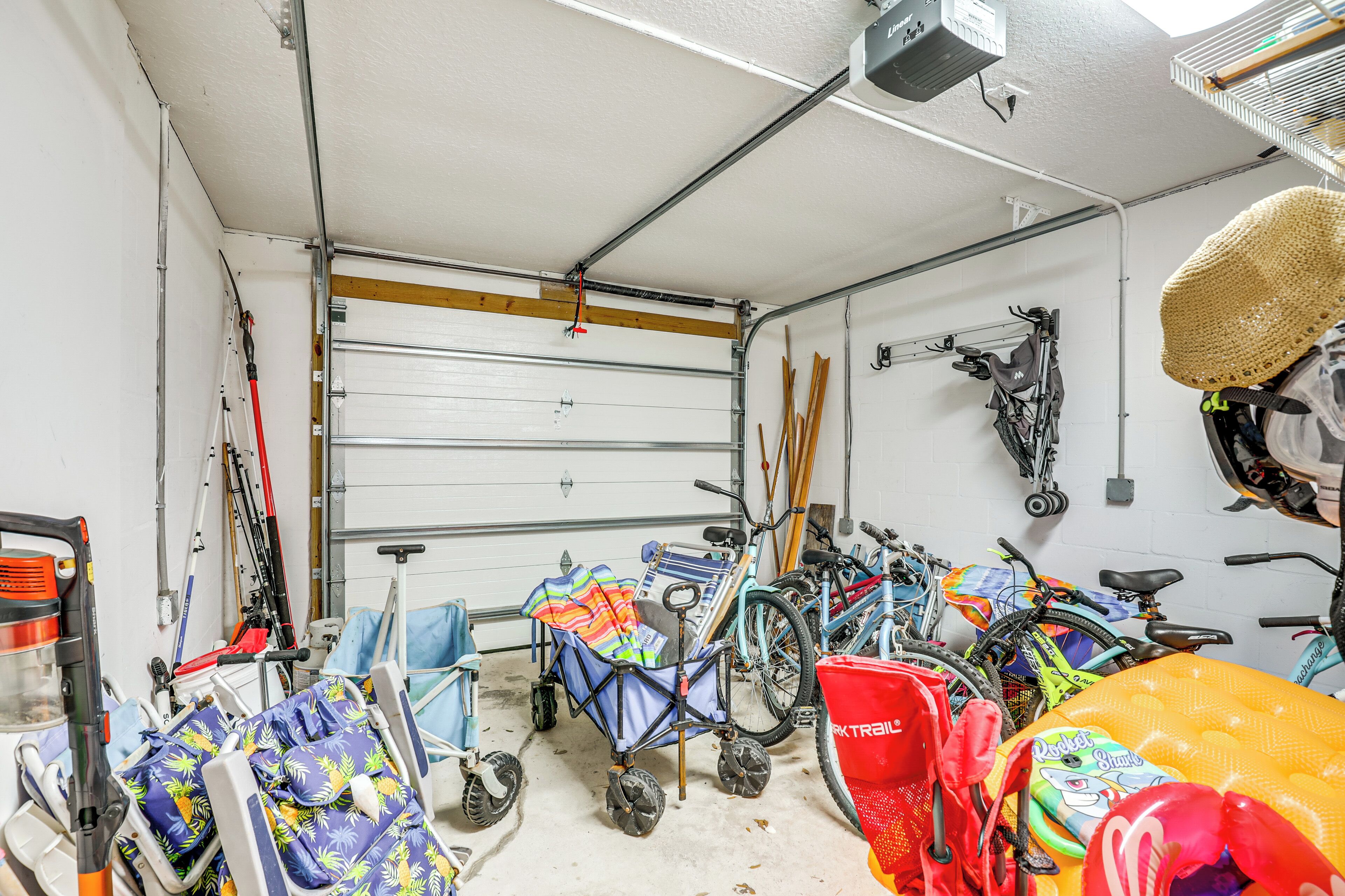 A garage with bicycles, a stroller, and various tools.