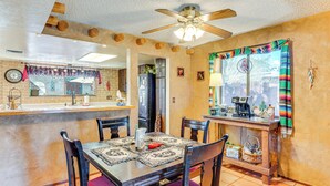 A dining area with a wooden table, chairs, and a ceiling fan. - Cyclists' Haven: Southwestern-style Home in Tucson (Tucson)