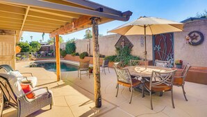 A covered patio area with a pool, outdoor seating, and a dining table. - Cyclists' Haven: Southwestern-style Home in Tucson (Tucson)