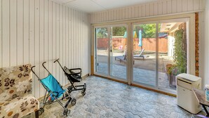 A room with a patterned sofa, a stroller, and a heater. - Family Home w/ Patio in Irving: Pets Welcome! (Irving)