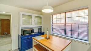A kitchen with a microwave, toaster, and a wooden table. - Family Home w/ Patio in Irving: Pets Welcome! (Irving)