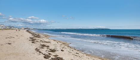 Ein Strand mit sandigem Ufer und Wellen.