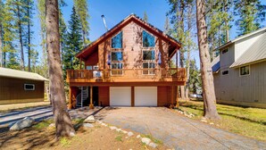 A two-story cabin with a balcony, garage, and a natural forest setting. - Neighborhood Beach Access! Soda Springs Getaway (Truckee)