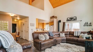 A spacious living room with a large brown leather sectional sofa, a fluffy rug, and a wooden ceiling. - Neighborhood Beach Access! Soda Springs Getaway (Truckee)