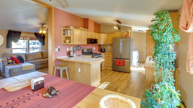 A compact kitchen with wooden cabinets, a refrigerator, and a microwave. - Stunning Views: Quiet Bluff Home Near Hiking! (Bluff)