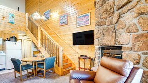 A cozy interior with a wooden staircase, a leather sofa, and a stone wall. - 2 Mi to Granby Ranch: Studio w/ Resort Amenities! (Granby)