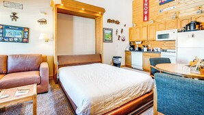 A cozy hotel room with a bed, a sofa, a small table, a kitchenette, and a bathroom. - 2 Mi to Granby Ranch: Studio w/ Resort Amenities! (Granby)