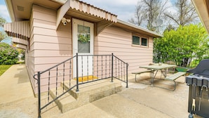 A single-story house with a front porch, a small table, and a grill. - Patio, Grill & Outdoor Dining: Conrad Home! (Conrad)