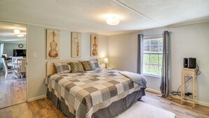 Una camera da letto con un letto grande, una scrivania e una finestra con tende.