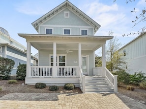 A two-story house with a covered porch and a front staircase.