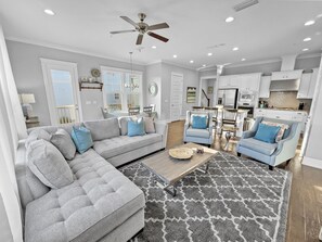 A modern living room with a sectional sofa, a coffee table, and a patterned rug.