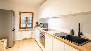 Een moderne keuken met een koelkast, oven, magnetron en spoelbak.