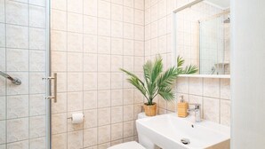 Een badkamer met toilet, wastafel en douche.