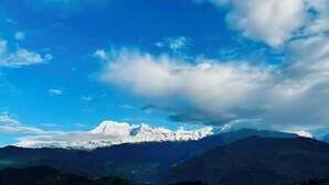 A mountain range with snow-capped peaks under a clear blue sky.