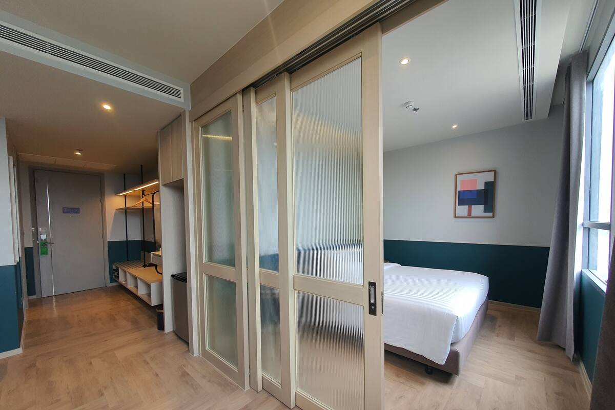 Une chambre d’hôtel équipée d’un lit, d’un bureau et d’une armoire aux portes coulissantes.