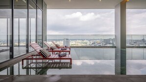Ein Hochhaus mit einem Glasbalkon und Blick auf eine Skyline.