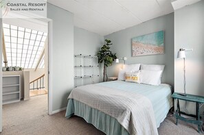 A bedroom with a bed, a nightstand, a lamp, a plant, a painting, and a view of a balcony. - 2 Bedroom Penthouse with Oceanfront Views! (Ocean City)