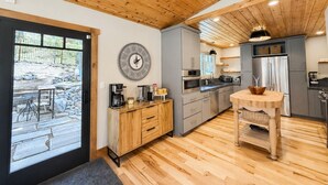 A modern kitchen with wooden flooring, a built-in oven, and a large clock on the wall. - Tahoe Retreat AC Hot Tub Backyard Oasis, Near Skiing & Beaches (SL397) (Stateline)