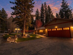 A two-story house with a red garage door, a stone pathway leading to the entrance, and a well-maintained lawn. - Tahoe Retreat w/ AC | Hot Tub+Backyard Oasis | Near Skiing & Beaches (SL397) (Stateline)