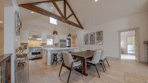 A spacious kitchen with a central island, wooden beams, and modern appliances. - Wilderness Club Haven for 12! (Eureka)