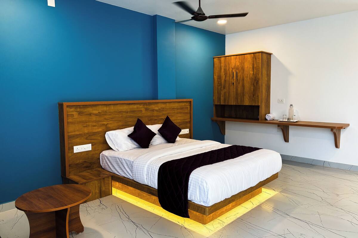 A bedroom with a wooden bed, a nightstand, a ceiling fan, and a wooden cabinet.