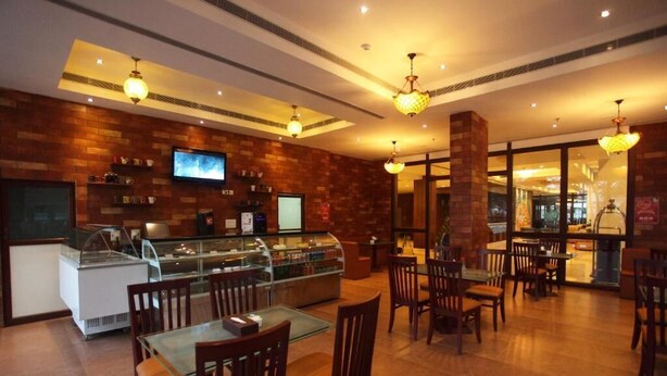 A restaurant with brick walls, wooden furniture, and glass display cases. - NO 18 HOTEL (Kochi)