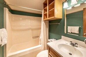 Ein Badezimmer mit Badewanne, Waschbecken und Spiegel.