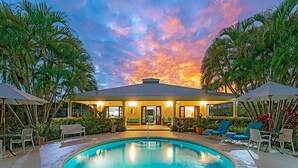 A pool area with a sunset view, lounge chairs, and a covered seating area. - Gibbs Glade Villa 4 Bedroom Home by Bluescape (Gibbes)