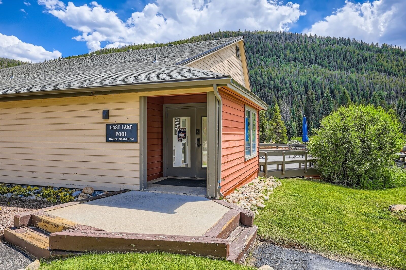 A lodge with a sign indicating 'East Lake Pool' and operating hours.