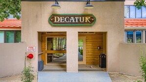 A building entrance with a sign reading "DECATUR" and a fire department connection sign. - 1776 Decatur 4 Bedroom Condo (Keystone)