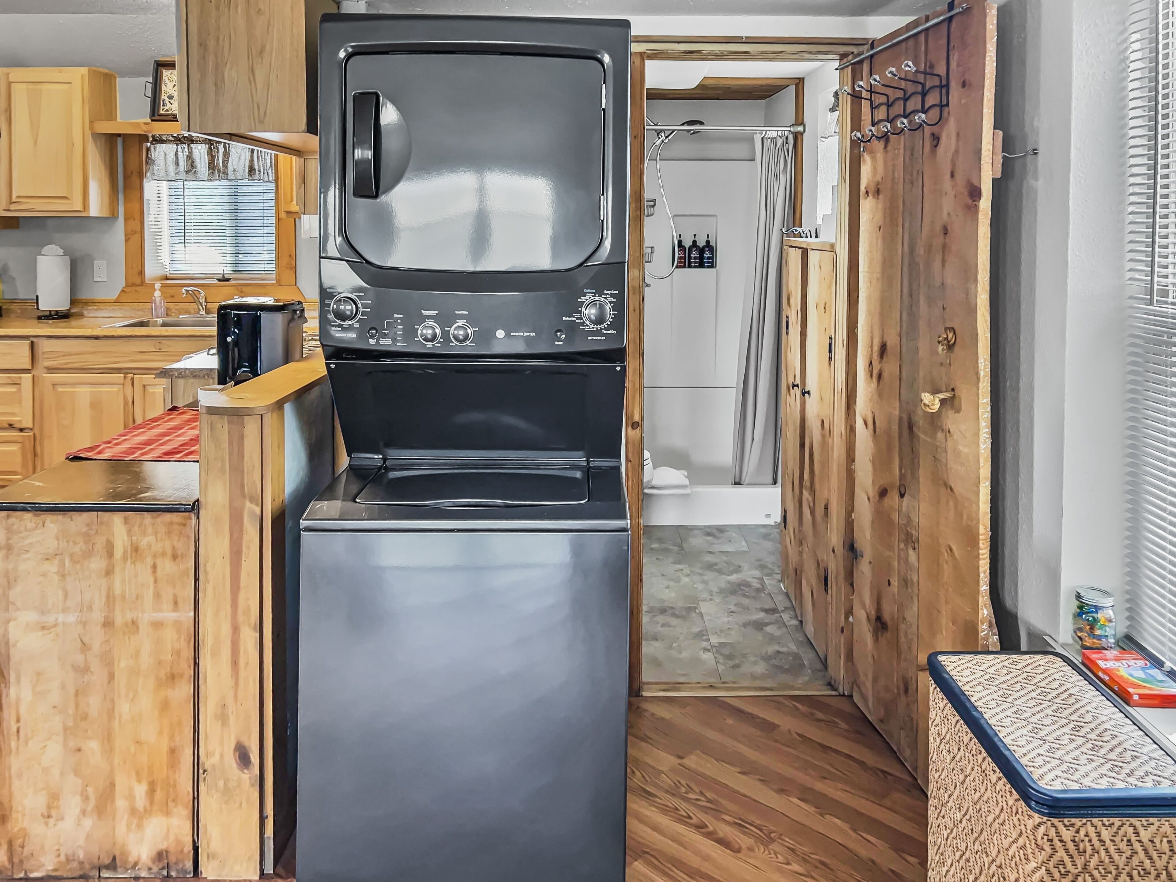 A compact kitchen with a built-in oven and microwave, wooden cabinets, and a small seating area.