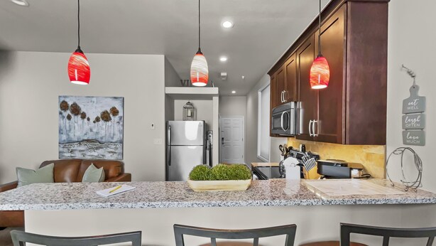 A modern kitchen with granite countertops, stainless steel appliances, and pendant lighting. - The Loft Of Historic Charm 1 Bedroom Condo (Grand Junction)