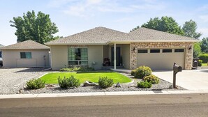 A two-story house with a garage, a front porch, and a well-maintained lawn. - Hermosa Haven 3 Bedroom Home (Montrose)