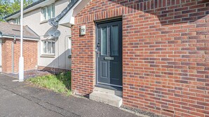A brick house with a black door and the number 72 on the wall. - Prime Commuters Choice Award by Three Bridges Apartments (Pitreavie Castle)