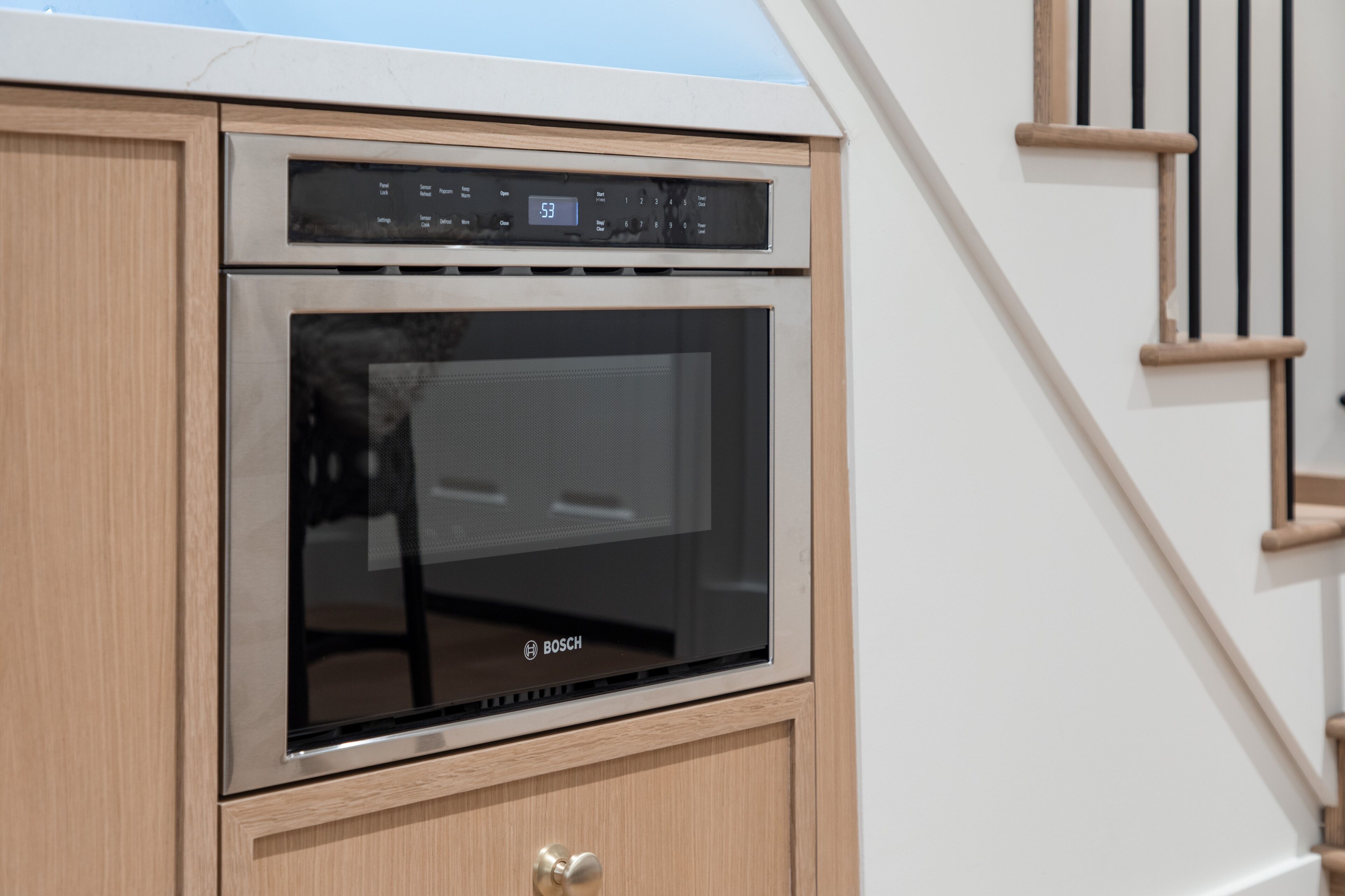 Una cocina moderna con horno Bosch y un armario de madera.