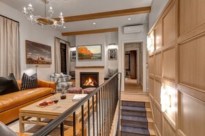 A spacious living room with a fireplace, leather sofa, and a staircase leading to another level. - Blue Church Lodge G 2 Bedroom Condo (Park City)