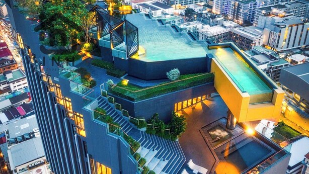 A high-rise building with multiple balconies, a rooftop garden, and a swimming pool.