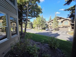 A residential street with houses, a driveway, and a grassy area.