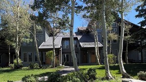 A multi-story residential building with a well-maintained lawn and mature trees. - Snowcreek Resort Vacation Rental 879 (Mammoth Lakes)