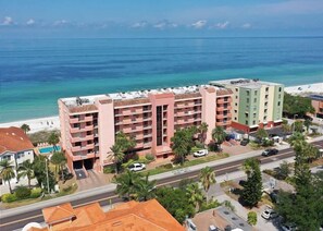 Ein mehrstöckiges Hotel mit Balkonen mit Blick auf Strand und Meer.