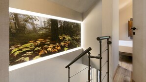 Un intérieur moderne avec une grande fenêtre donnant sur un paysage forestier.