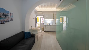Ein modernes Interieur mit Essbereich, Küche und einer blauen Sitzsofa-Kombination.