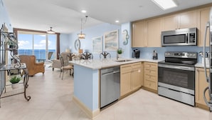 A modern kitchen with a built-in dishwasher, stainless steel appliances, and a large island with a sink.