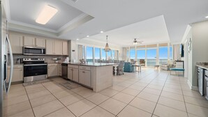 A spacious kitchen with a large island, modern appliances, and a view of the ocean. - 4BR Beachfront, Lazy River w/ Slide, New to Market!! (Orange Beach)