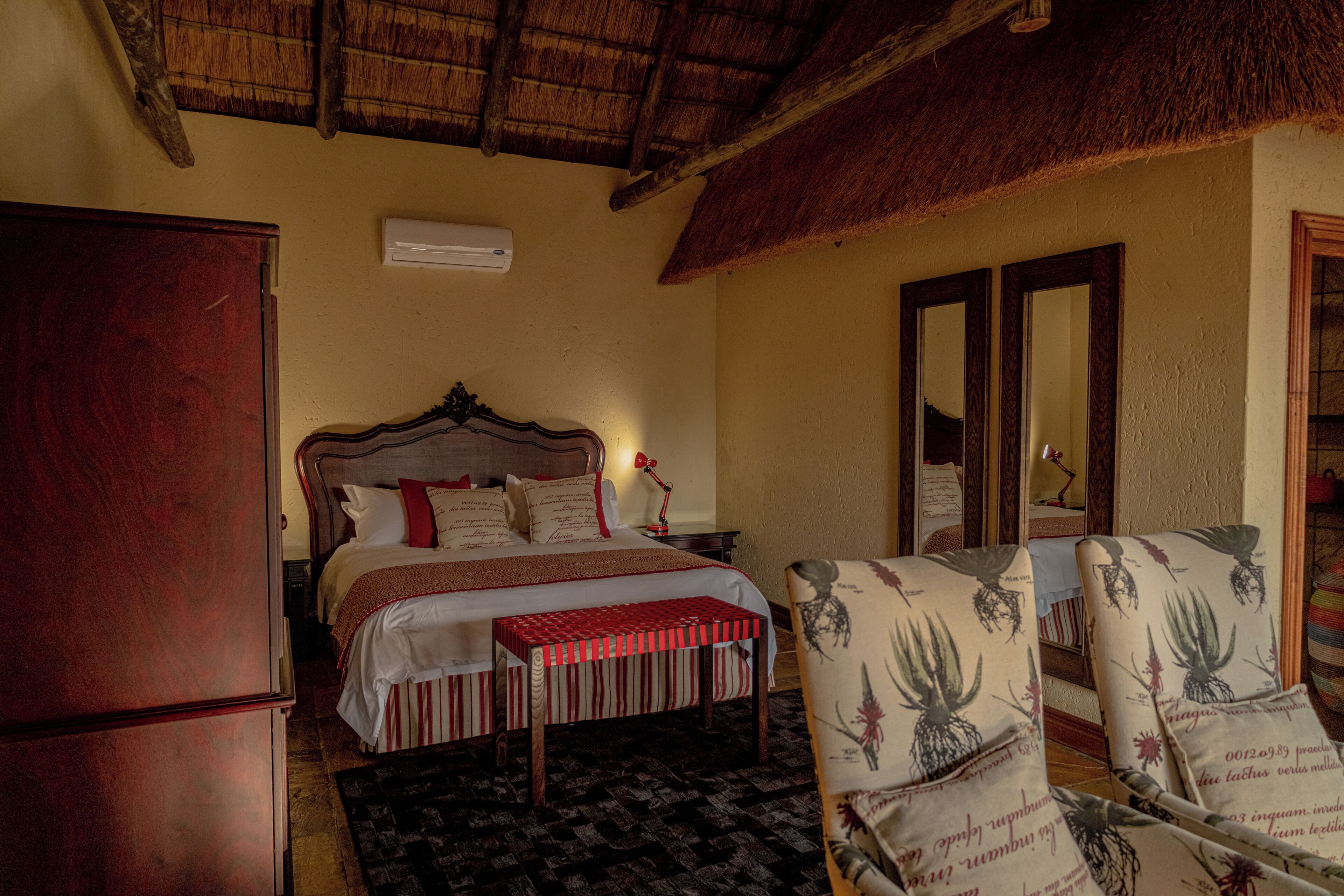A bedroom with a bed, bedside table, and a chair with a floral pattern.