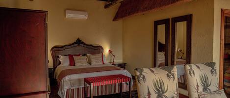 A bedroom with a bed, bedside table, and a chair with a floral pattern.
