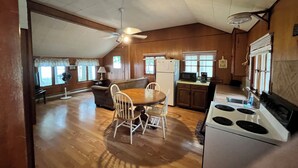 Una cocina amplia con comedor, pisos de madera y un ventilador de techo.