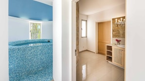 A modern interior with a blue-tiled swimming pool, a wooden door, and a bathroom with a mirror and chandelier. - Villa Zoey - Three Bedroom Villa, Sleeps 6 (Theletra)